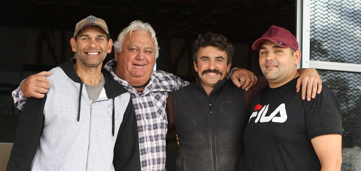 Four men smiling together at the Josiah Healing Centre construction site.